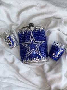 two blue and white flasks, one with a star on the side sitting on a bed