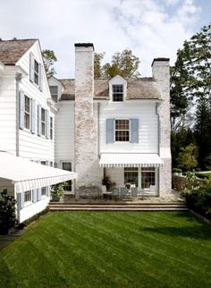 a large white house sitting on top of a lush green field