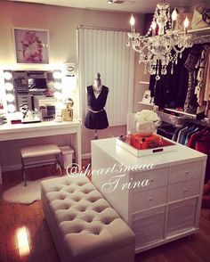 a room with a vanity, dressing table and chandelier hanging from the ceiling