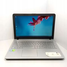 an open laptop computer sitting on top of a white table next to a credit card