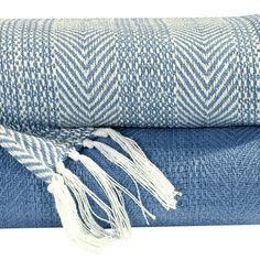 two blue and white towels folded on top of each other with tassels hanging from them