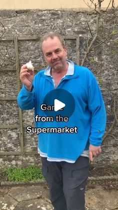 a man standing in front of a brick wall holding something up to his face with the words gar from the supermarket on it