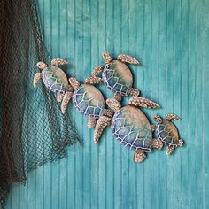 three sea turtles sitting on top of each other in front of a net and blue wall