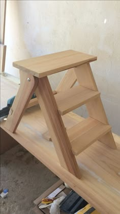 a wooden step stool sitting on top of a hard wood floor