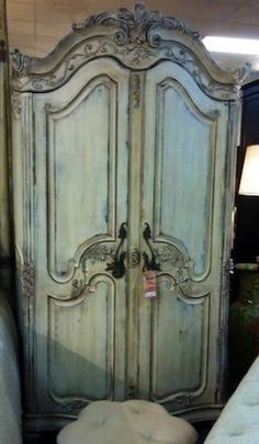 an old white armoire in a store