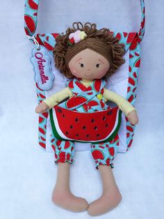 the doll is wearing a red and blue outfit with a watermelon print on it