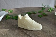 a white shoe sitting on top of a wooden table next to a glass of wine