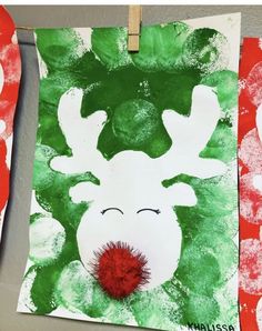 paper plate reindeers are hanging on the clothes line with green and red paint in front of them