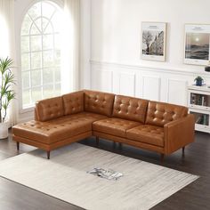 a brown leather sectional sofa sitting on top of a white rug in a living room