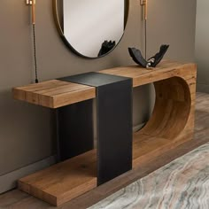 a modern console table with an oval mirror on the wall