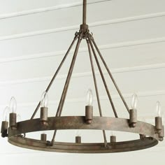 a chandelier with six lights hanging from it's center ring and four candles on each end