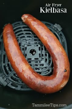 an air fryer with two sausages in it and the words, air fryer kielbasa