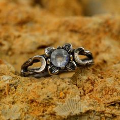 a silver ring sitting on top of a rock