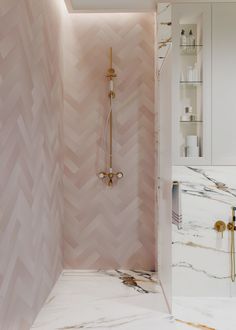 a bathroom with pink walls and gold fixtures on the shower head is shown in this image