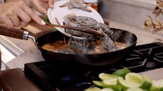 a person cooking food in a skillet on the stove