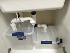 two plastic containers under a white sink