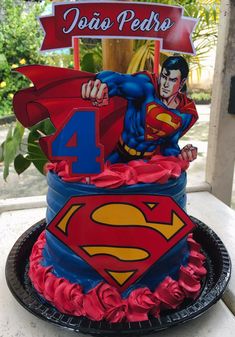 a superman birthday cake with the number four on it