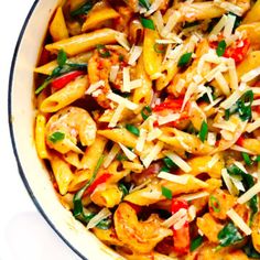 a bowl filled with pasta and vegetables covered in parmesan cheese