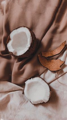 two halves of coconuts sitting on top of a bed