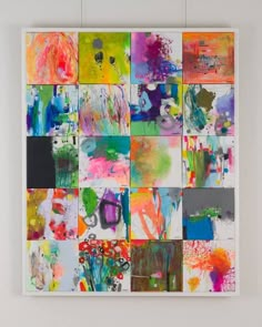 an abstract painting is hanging on the wall in front of a white frame with multiple different colors