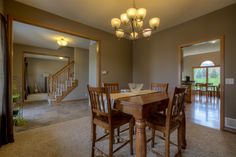 a dining room table with four chairs and a chandelier