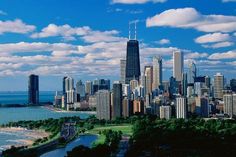 an aerial view of the chicago skyline with lake michigan in the foreground and clouds in the background