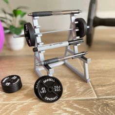 a barbell weight rack and two dumbs on a table