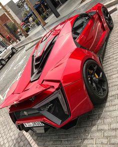 a red sports car is parked on the street