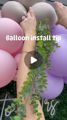 someone is holding balloons in the air with greenery on them and text balloon install tip