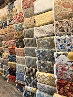 many different types of fabric on display in a store or showroom, all lined up together