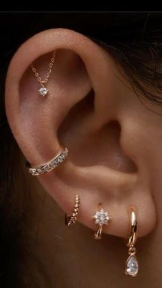 an ear with three different types of piercings on it's sides and one is attached