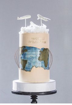 there is a cake that has been decorated with an airplane and globe on top of it