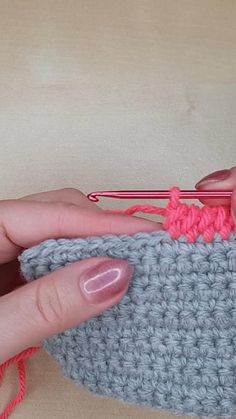 someone is crocheting the yarn on top of an object with their fingers and thumbnails