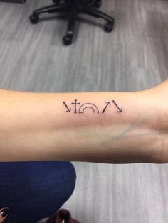 a woman's arm with the word tattoo on it, in front of a computer desk