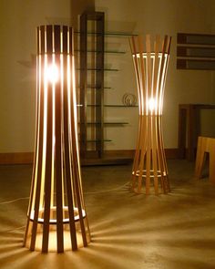 two tall wooden lamps sitting on top of a floor