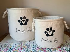 two white baskets with dogs paw prints on them