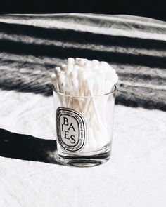 a glass filled with marshmallows sitting on top of a white table cloth