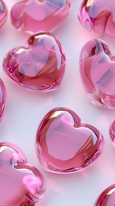 many pink heart shaped objects on a white surface with light reflecting off the top one