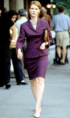 a woman in a purple suit walking down the street