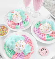 three white plates topped with waffles covered in frosting and sprinkles