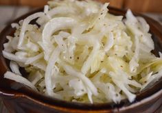 a wooden bowl filled with sauerkraut on top of a table