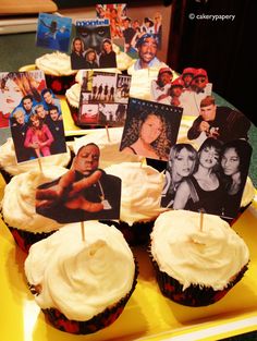 cupcakes with pictures on them sitting on a yellow plate in the middle of a table