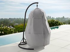 a large gray bag sitting on top of a tiled floor next to a swimming pool