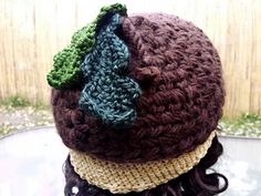 a crocheted hat is sitting on top of a woman's head,