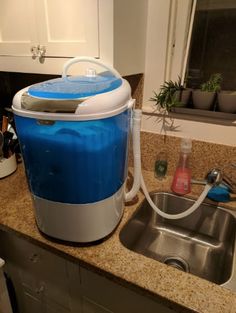 a blue and white cooler sitting on top of a kitchen counter next to a sink