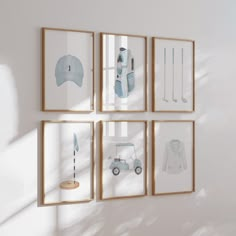 four framed pictures hang on the wall in front of a white wall with blue artwork