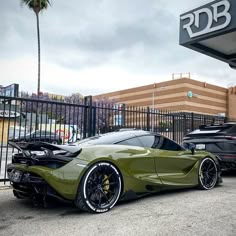 some very nice looking cars parked in front of a parking lot at a car dealership