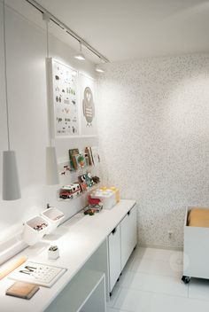 a white room with a desk, chair and shelf on the wall next to it