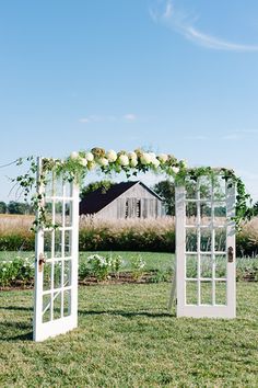 an outdoor ceremony setup with white flowers and greenery