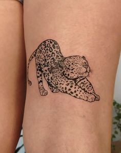 a black and white tattoo of a leopard on the leg